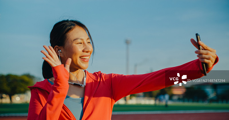 亚洲女运动员与健身教练进行视频通话图片素材