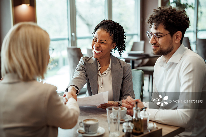 同事在餐厅咖啡休息期间握手图片素材