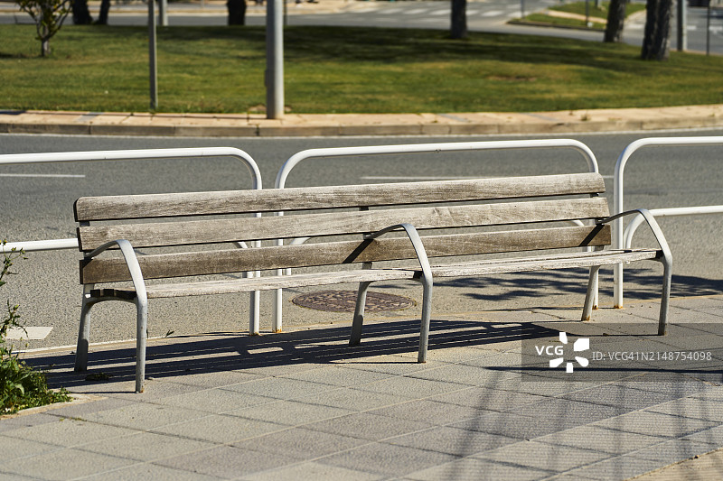 道路人行道上一组木制长椅的正面景观图片素材
