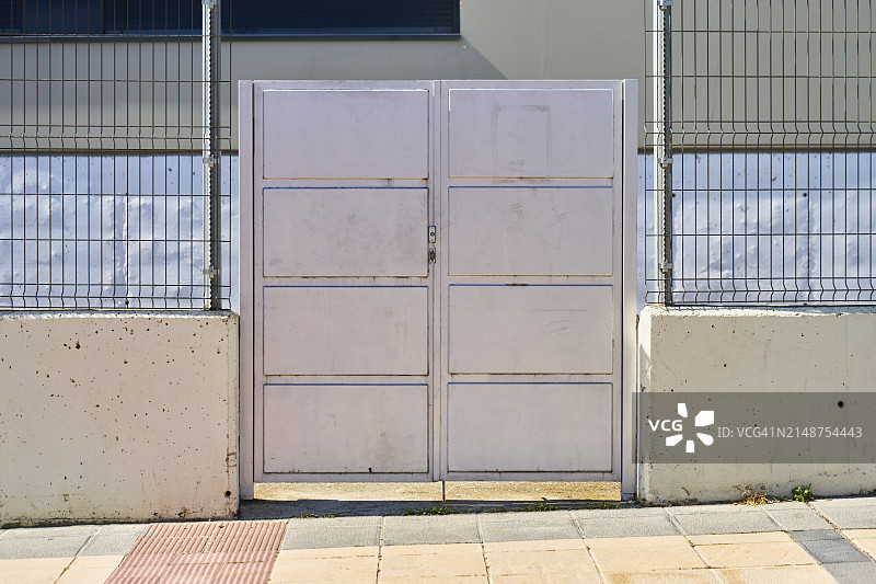 封闭建筑物外围围栏上的大门正面图，周围无人图片素材