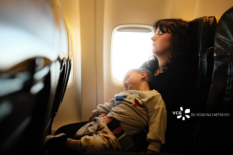 小男孩在飞机上和妈妈一起睡觉图片素材