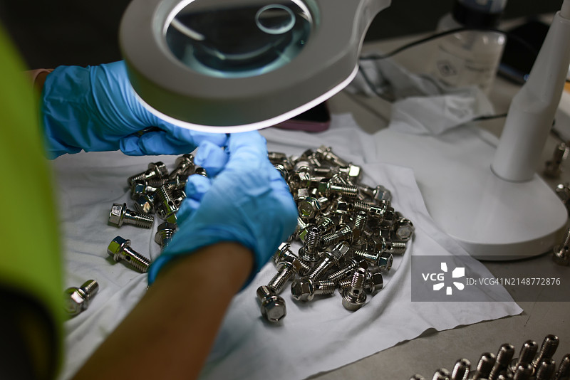 工作人员检查紧固件的质量，工业汽车零件图片素材
