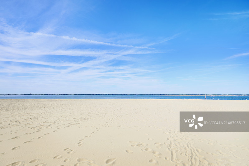 阳光明媚的空旷海滩，蓝色天空图片素材