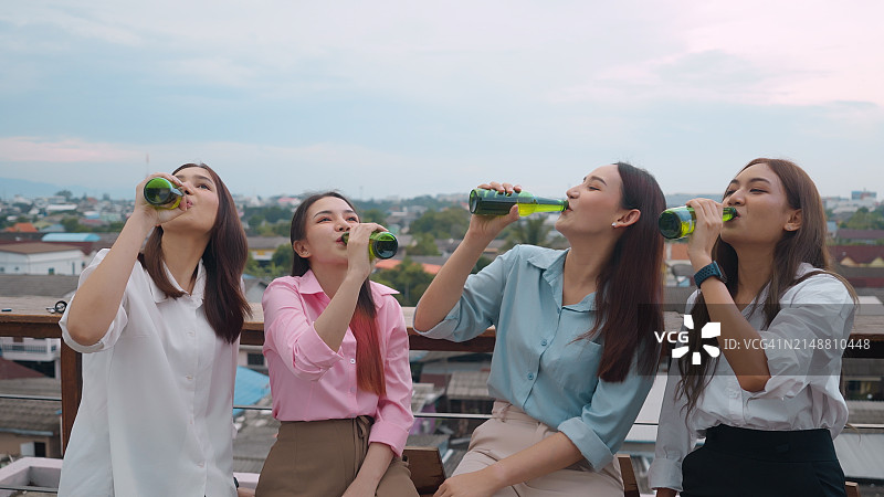 四名年轻人在屋顶派对上举杯庆祝图片素材