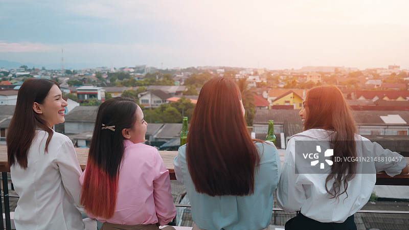 四名年轻人在屋顶派对上举杯庆祝图片素材