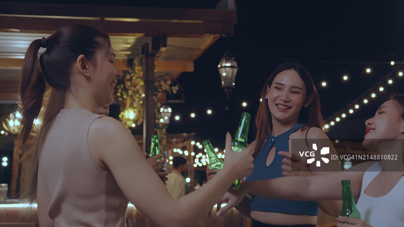 一群迷人的女人在豪华酒吧享受和开心聚会，一起喝花式鸡尾酒。快乐的女性朋友在城市夜总会庆祝节日活动图片素材