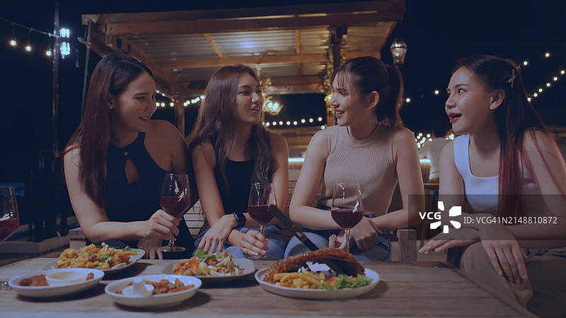 与好友在豪华酒吧享用小吃和饮品的欢乐聚会图片素材