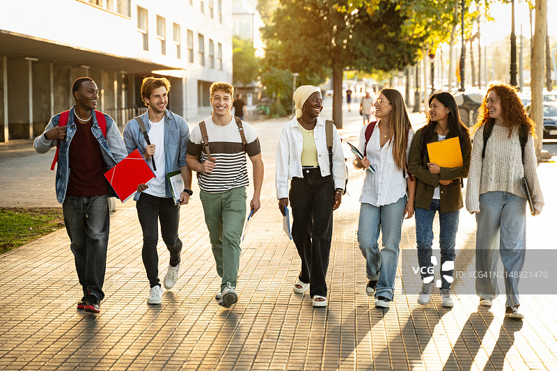 在城市里一起行走的多元种族Z世代学生朋友。青年多样性图片素材
