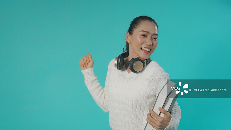 戴着耳机跳舞的快乐亚洲女性图片素材