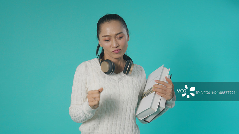 戴着耳机跳舞的快乐亚洲女性图片素材