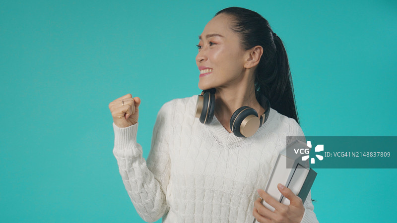 戴着耳机跳舞的快乐亚洲女性图片素材