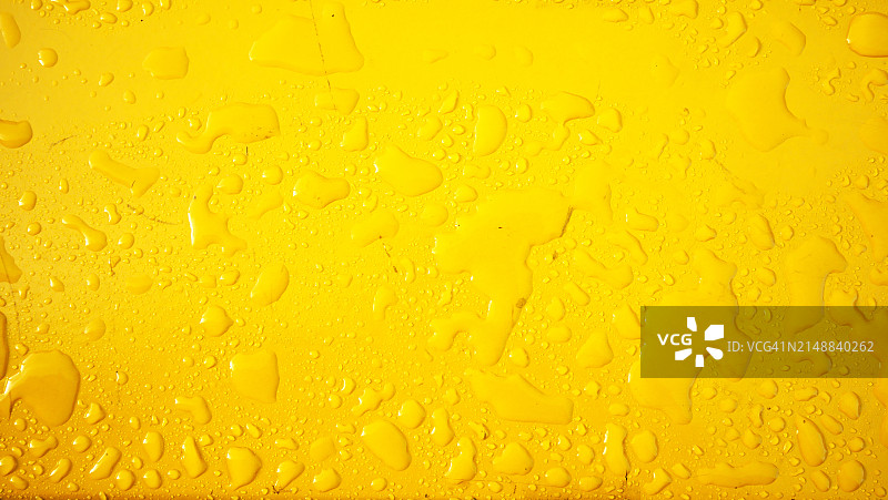 英国伦敦，被雨水浸湿的黄色金属板特写，干净光滑，阳光充足，自然色彩图片素材
