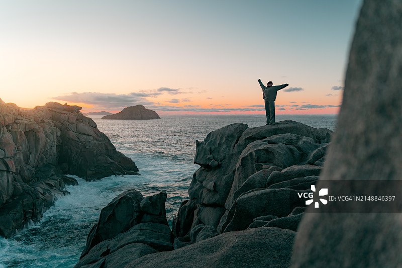 夕阳下纸悬崖上的快乐年轻女人图片素材