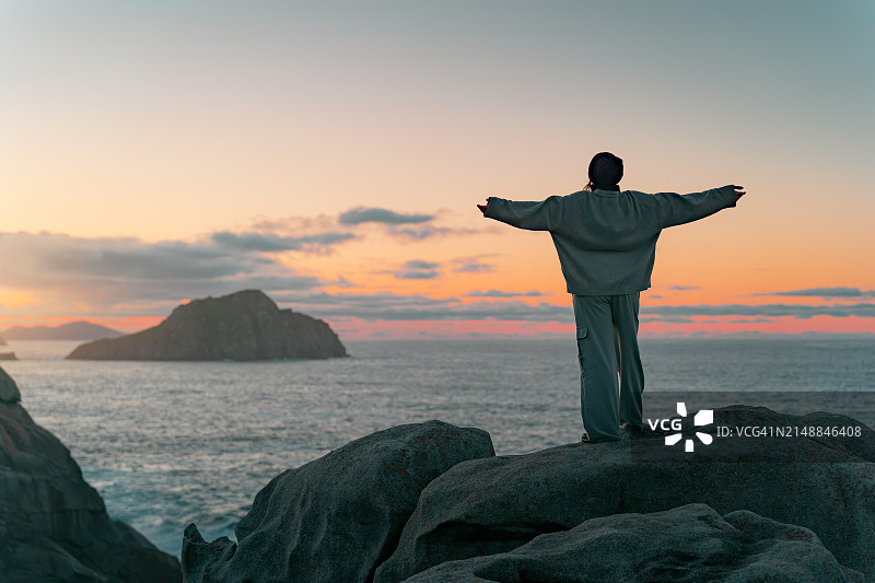 在纸崖欣赏日落，在纸崖的地平线上沉思的女人图片素材