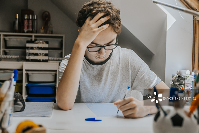 在家书桌前感到疲惫和焦虑的学生图片素材