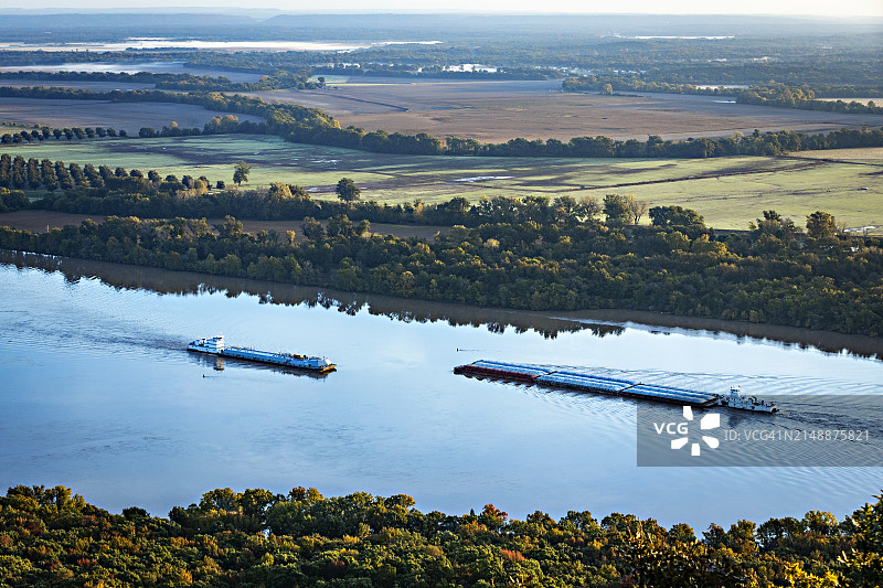 两艘商业驳船在阿肯色州的阿肯色河上相遇图片素材