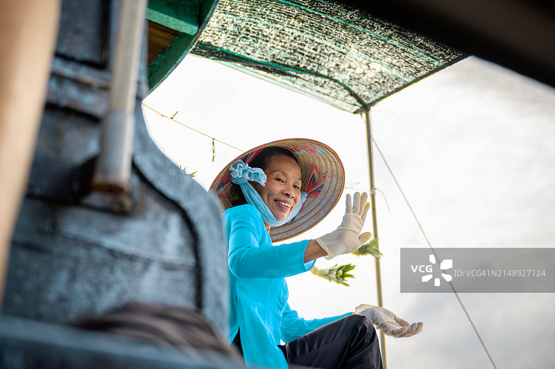在湄公河三角洲水上市场上的越南老年妇女肖像图片素材