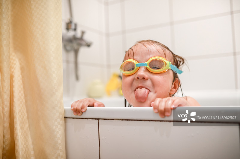 儿童沐浴：戴游泳镜的小朋友在家享受沐浴时光图片素材