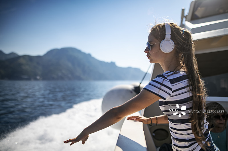在意大利坎帕尼亚阿马尔菲海岸附近乘渡轮旅行的可爱青少年女孩图片素材