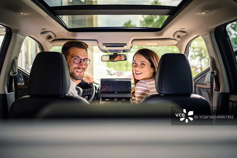 年轻情侣坐在他们的新车里图片素材