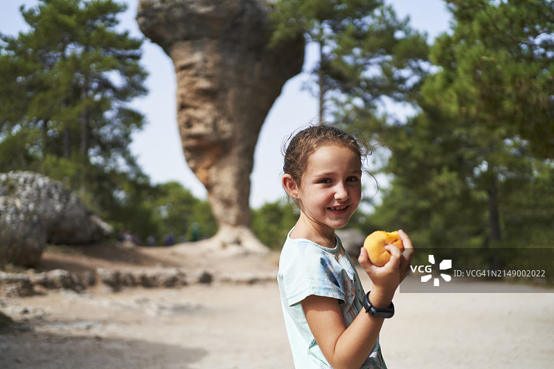 昆卡手拿水果的可爱小女孩侧面肖像图片素材