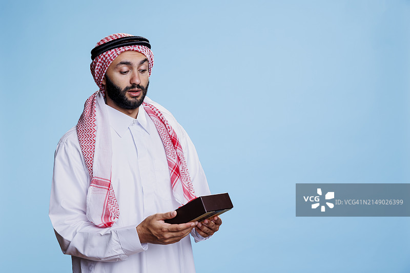 穆斯林男子拿着包装好的礼品盒图片素材