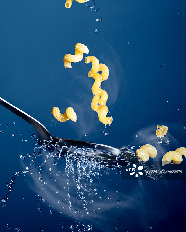 蓝色背景下的水花与意大利面特写图片素材