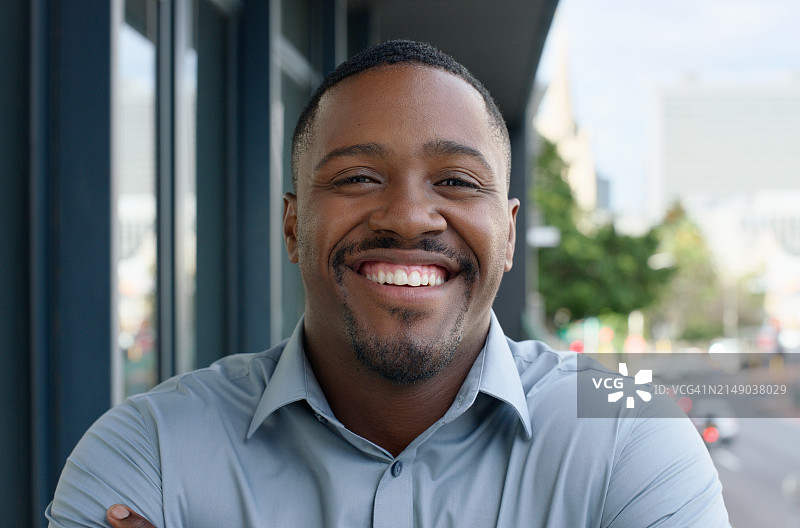 黑人男子在城市户外休息时的商务微笑人像图片素材