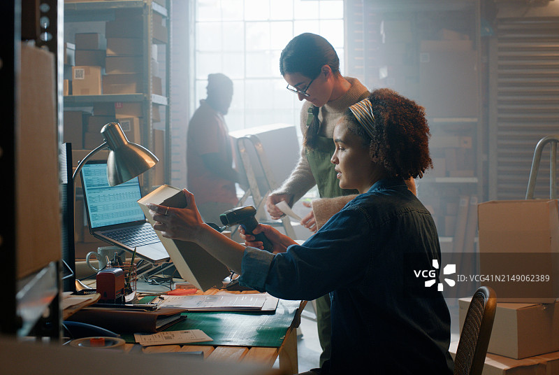 使用扫描仪的电商女员工图片素材