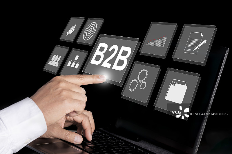 B2B营销概念：企业对企业，电子商务，商人使用带有B2B图标的笔记本电脑在虚拟屏幕上操作图片素材