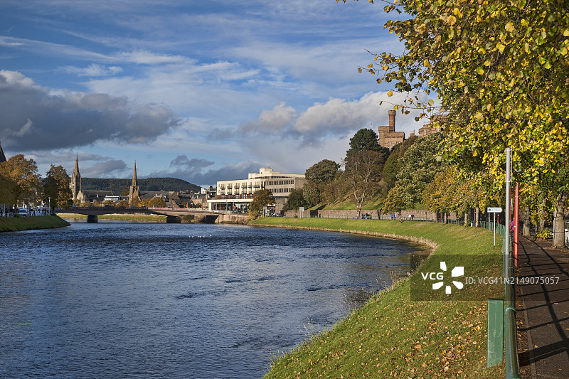 从城堡路的河边步道(Great Glen Way - 显示路标)向北俯瞰尼斯河,可看到因弗内斯市中心。 展示了步行进城的人们和右侧树木上方的城堡。 因弗内斯市,高地地区,苏格兰,英国图片素材