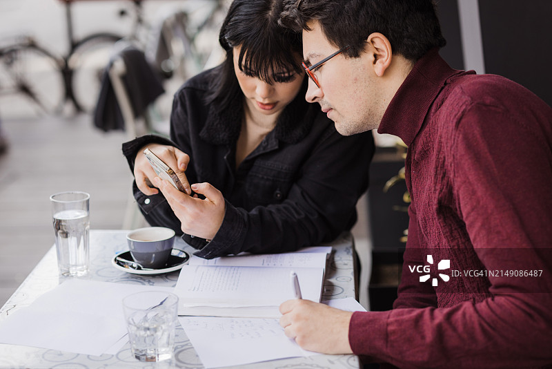 学生们在完成作业时使用智能手机图片素材