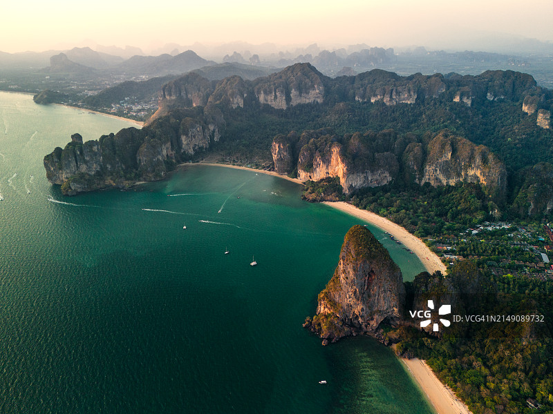 航拍：泰国甲米府莱利海滩的绿色矮山、椰林和长尾船景观图片素材