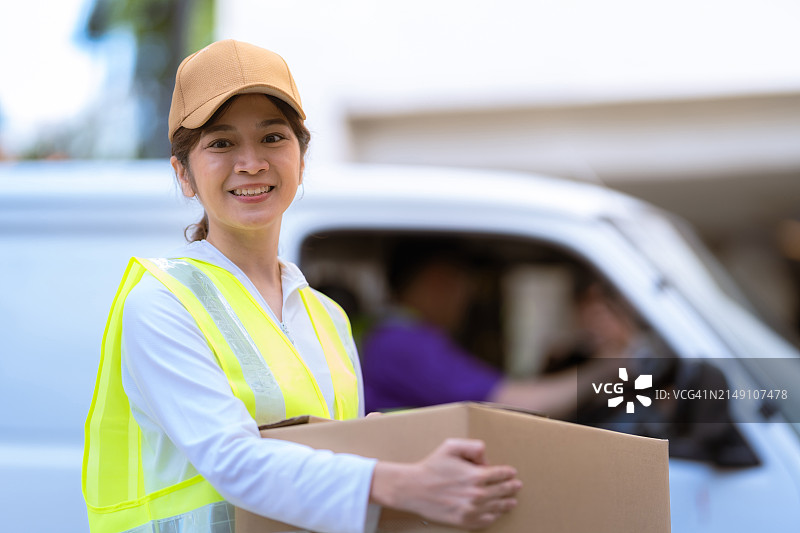 亚洲女配送员处理包裹图片素材