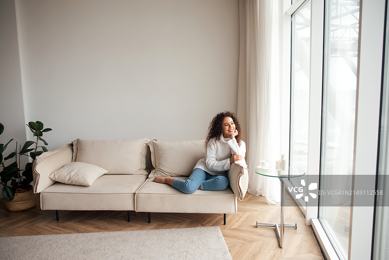 深色皮肤女人坐在沙发上休息图片素材