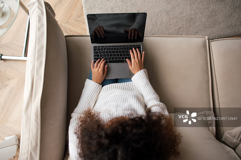 黑人女性在笔记本电脑上工作。远程工作。自由职业。网上购物。图片素材