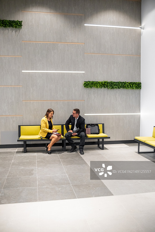 商人与女商人在商务大厅休闲交谈图片素材