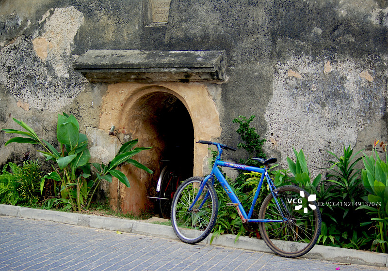 旧墙旁的蓝色自行车图片素材
