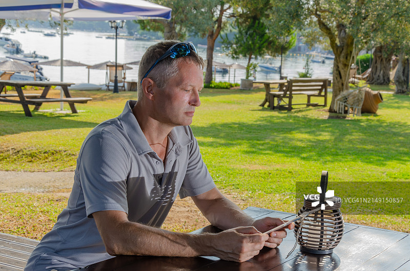 坐在公园里使用手机的男人图片素材