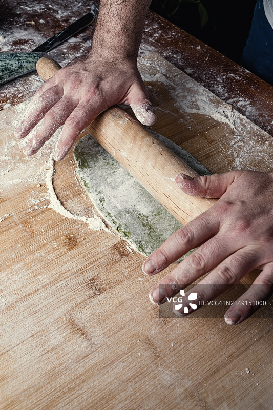 男人在桌子上揉面团图片素材