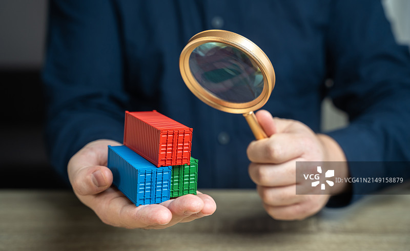 商人坐在办公桌前手持放大镜的半身照图片素材