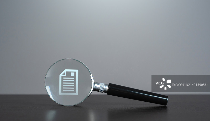 灰色背景下桌子上放大镜的特写图片素材