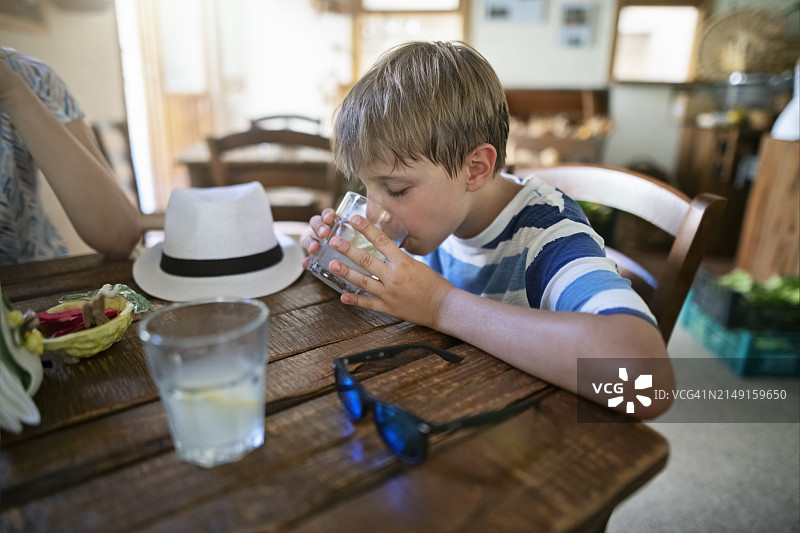 口渴的小徒步旅行者在小酒吧喝冰镇柠檬水图片素材