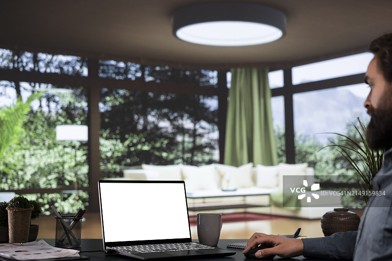 商务人士在办公室办公桌前使用笔记本电脑的侧视图图片素材