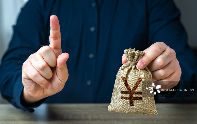 商人拿着硬币放在桌子上的半身照图片素材