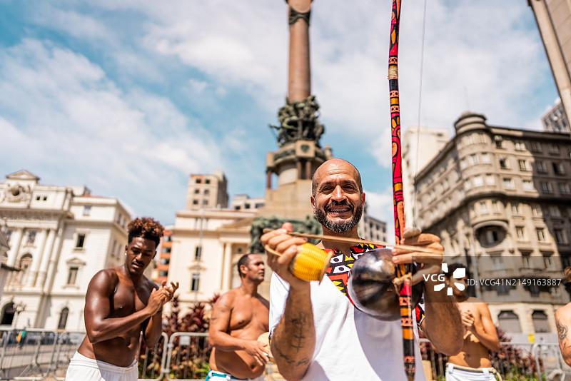 在巴西圣保罗演奏berimbau乐器的卡波耶拉中年男人画像图片素材