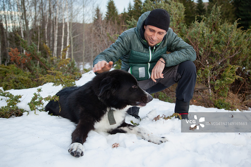 男子与狗在保加利亚的雪地上图片素材