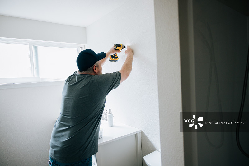 男人安装浴室镜图片素材