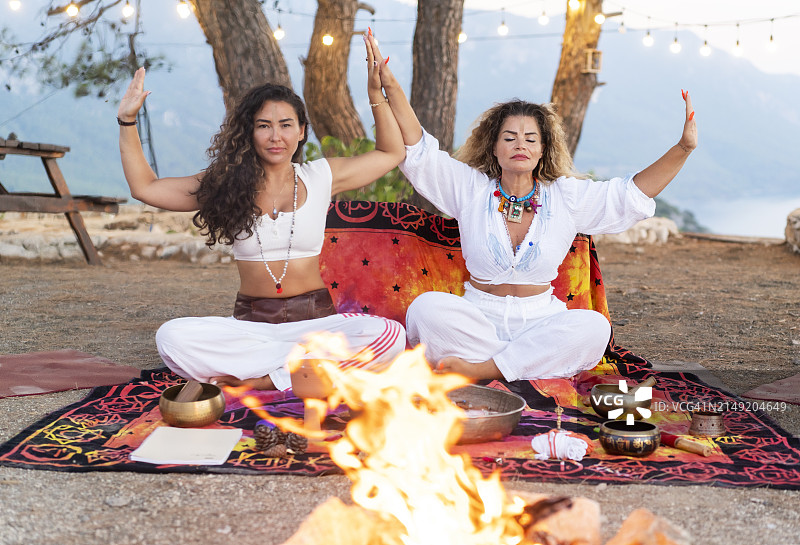 两名中年妇女在壁炉前做瑜伽图片素材