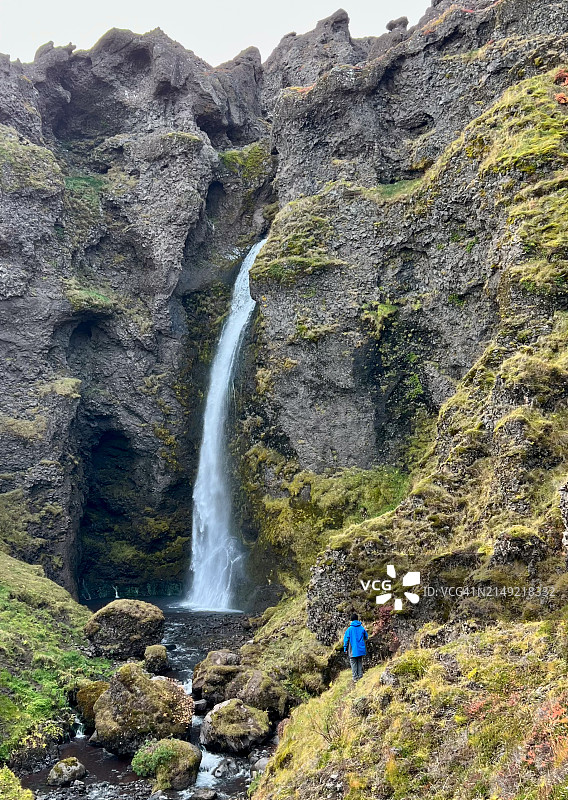 男人站在Grofarlaekjarfoss瀑布旁，冰岛南部图片素材
